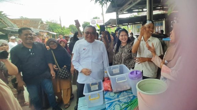Calon Bupati (Cabup) Sukabumi Nomor Urut 1 Iyos Soemantri menghadiri acara jajanan gratis di Kampung Mariuk, Desa Cidadap, Kecamatan Simpenan, Kabupaten Sukabumi pada Rabu (9/10/2024).