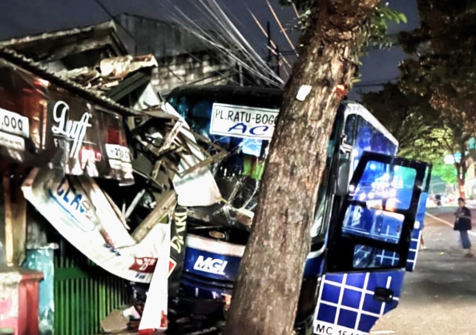 Sebuah bus jurusan Palabuhanratu–Bogor berhenti di lokasi kejadian usai menabrak pohon dan bangunan. Insiden ini menewaskan sang sopir yang tertabrak busnya sendiri. (Foto: Istimewa)